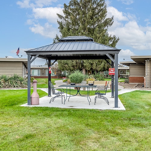 A gazebo with tables and chairs outside at Linden Post Acute